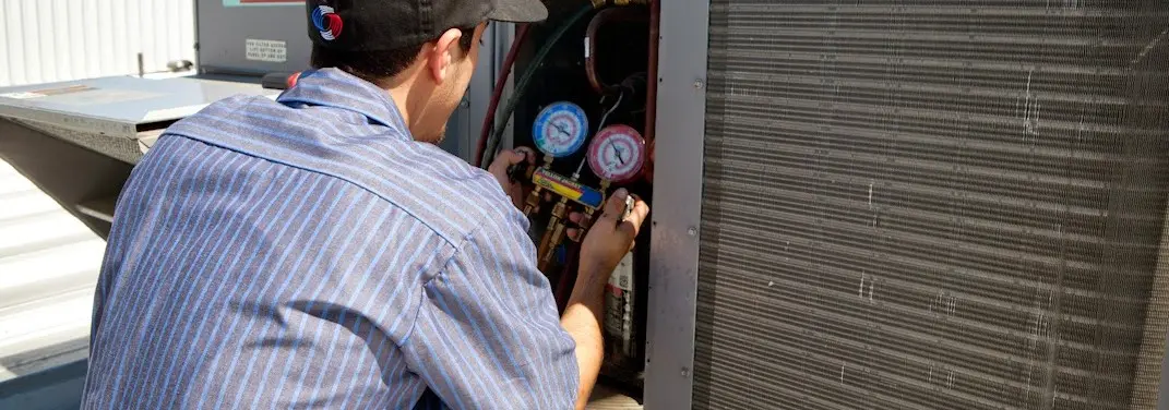 HVAC technician servicing a condenser unit in Point Pleasant Beach